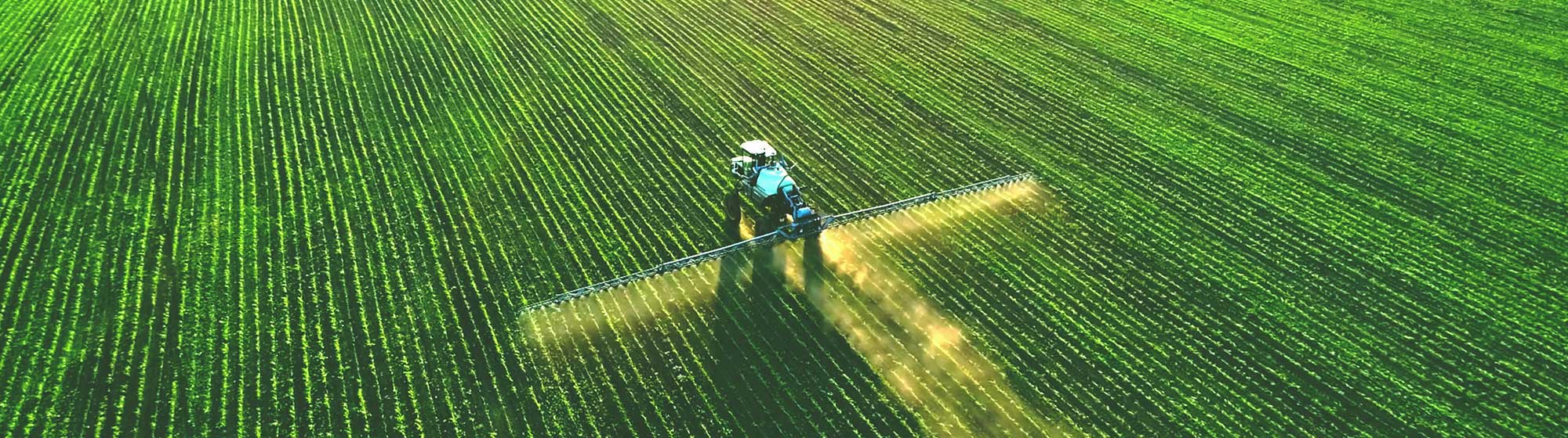 A spreading machine that sprays a product in a green field. Agricultural equipment is integrated into SIA’PRO.